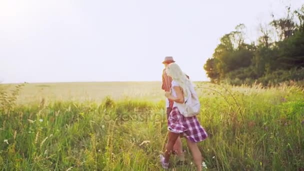 Man with map and girlfriend walking through field - Záběry, video