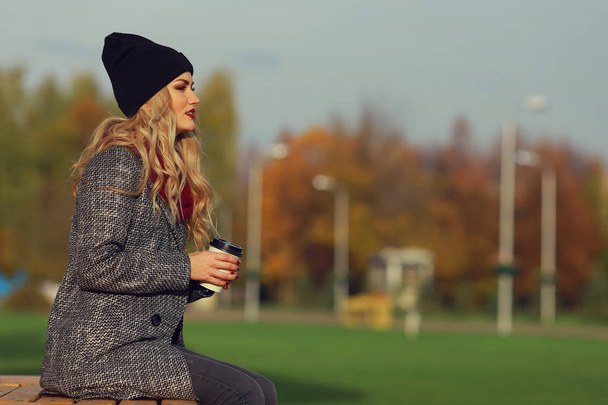 Młoda kobieta stylowa z kawą w parku. miejsce - Zdjęcie, obraz