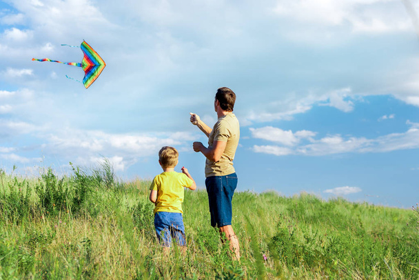 Calm father entertaining with his child on grass field - Zdjęcie, obraz