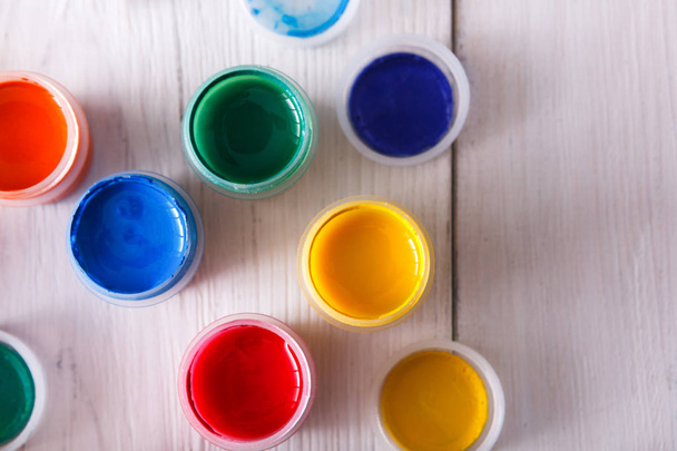 Artist workplace, set of color paints on wood desk - Фото, изображение