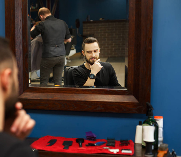 Man getting haircut by hairstylist at barbershop - Фото, изображение