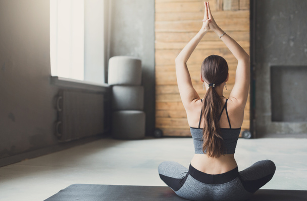 Mladá atraktivní žena cvičí jógu v padmásaně - Fotografie, Obrázek