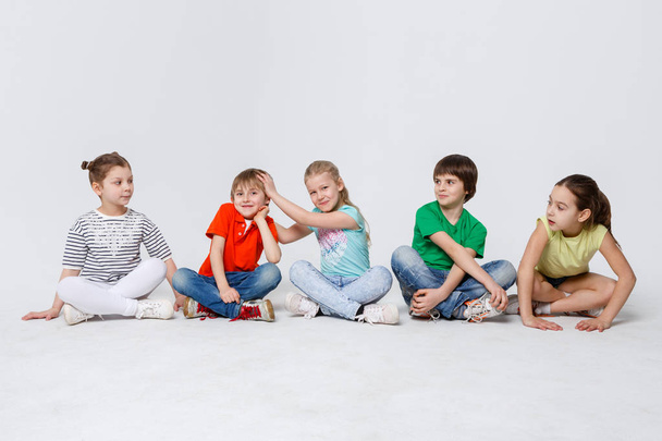 Happy kids sitting on floor at studio, copy space - Fotó, kép
