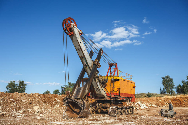 Grosso escavatore industriale a cava d'arancia in cantiere
 - Foto, immagini
