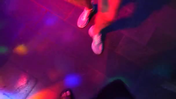 Γυναικεία πόδια σε ασημί παπούτσια χορεύουν στην πίστα στο ντίσκο μπαρ. Φως από safitov. 4k - Πλάνα, βίντεο