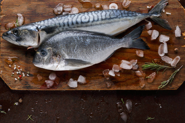 Fresh mackerel on wooden board at brown background - Fotó, kép