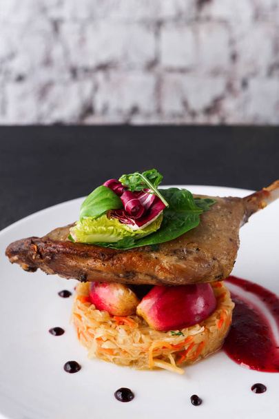 Restaurace jídla. Konfitované kachní stehno se zeleninou na černém pozadí - Fotografie, Obrázek