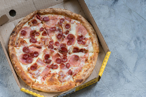 Pizza in box on concrete table, closeup - Фото, изображение