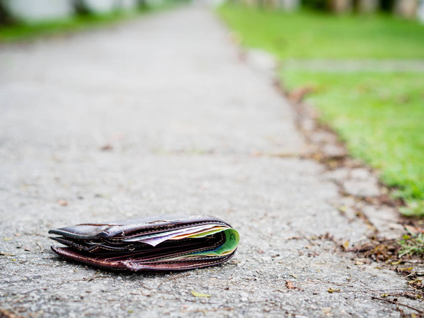 Ztracené koženou peněženku s penězi kapka na chodníku, ztracené peníze koncept, kopie místo na vrcholu. - Fotografie, Obrázek