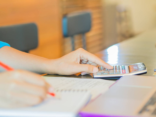 Primo piano mano donna d'affari utilizzando una calcolatrice con matita rossa in ufficio caffè. Concetto di finanza aziendale e istruzione
. - Foto, immagini