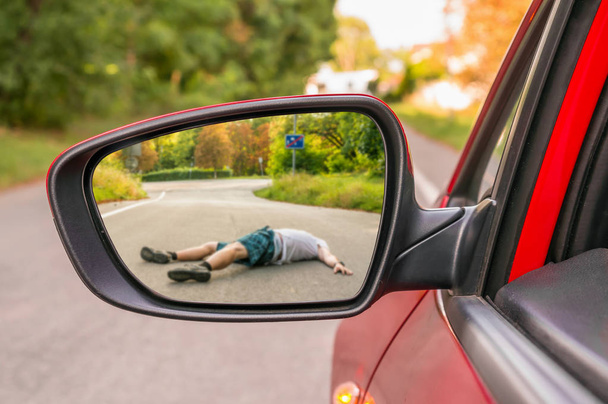 Rearview καθρέφτη με έναν άνθρωπο που χτυπήθηκε από ένα αυτοκίνητο - Φωτογραφία, εικόνα
