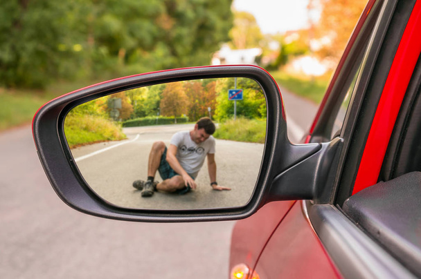 Rückspiegel mit Mann, der von Auto angefahren wird - Foto, Bild