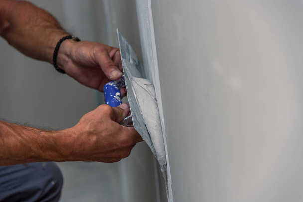 vieil ouvrier avec des outils de plâtrage mural rénovation maison
 - Photo, image