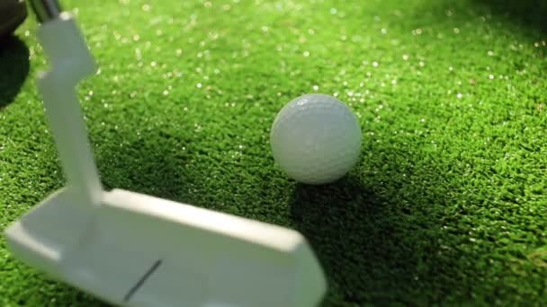 Zbliżenie golfisty za pomocą miotacza, aby zatopić krótki putt w otworze - Materiał filmowy, wideo