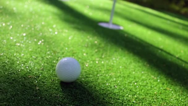 Közelkép golfozó segítségével putter süllyedni rövid putt lyukba - Felvétel, videó