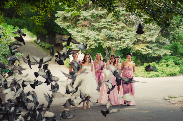 Νύφη με παράνυμφοι σε ροζ φορέματα για μια βόλτα - Φωτογραφία, εικόνα