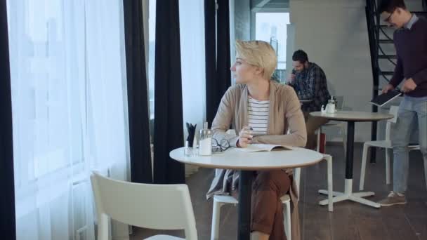 Gente disfrutando del café, trabajando y comunicándose en la cafetería por la mañana
 - Imágenes, Vídeo