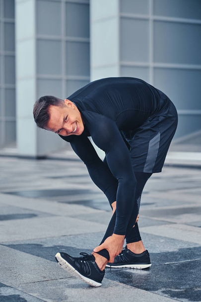 Man stretching outdoors over modern building - Photo, Image