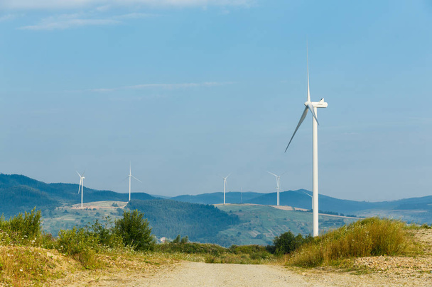 Turbinas de viento de pie en un talón entre los campos
  - Foto, imagen