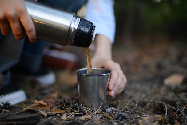 Κορίτσι ταξιδιώτης έκχυση τσάι από την κούπα θερμός, σε εξωτερικούς χώρους. Νέοι woma - Φωτογραφία, εικόνα
