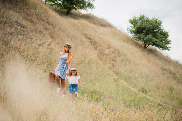 mother and daughter walking on hill - Foto, imagen
