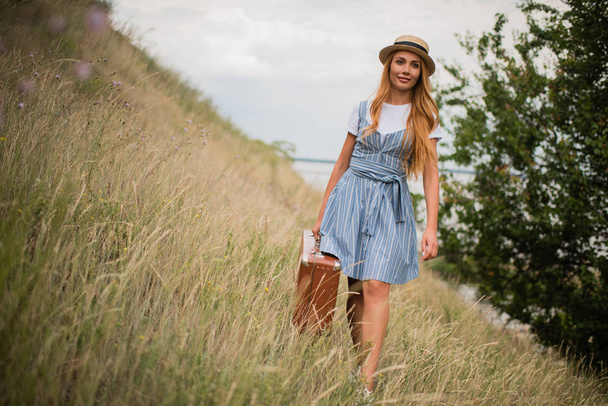 girl with suitcase on grassland - Foto, Imagem