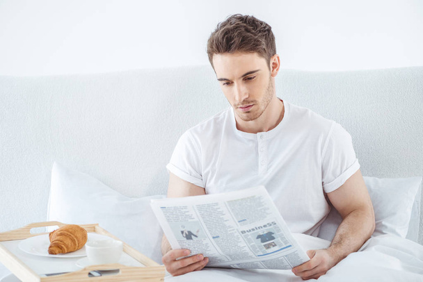 man with newspaper in bed  - Photo, Image