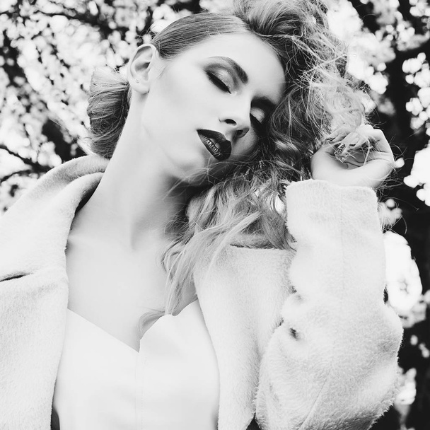 Young beautiful blonde woman posing in coat outdoors - Valokuva, kuva