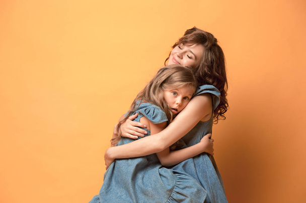 Madre incinta con figlia adolescente. Studio di famiglia ritratto su sfondo marrone
 - Foto, immagini