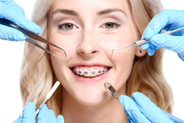 Руки, що тримають інструменти стоматолога біля жінки
 - Фото, зображення