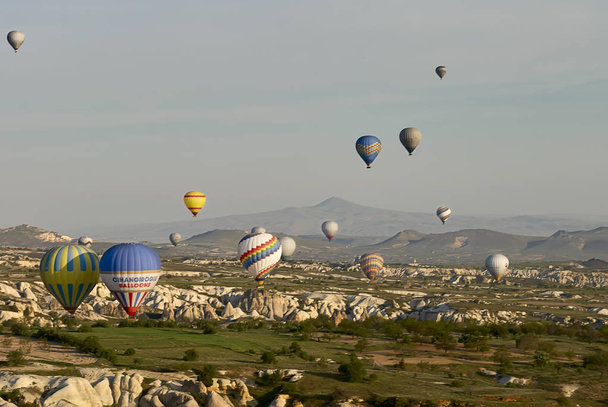 熱気球朝は谷の上を飛んでします。カッパドキア。トルコ - 写真・画像