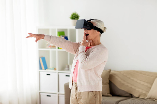 old woman in virtual reality headset or 3d glasses - Фото, изображение