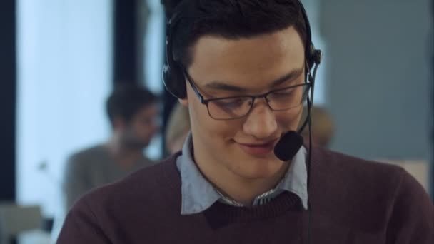 Működő-on egy számítógép-ban egy hív központ mosolygós fiatalember - Felvétel, videó