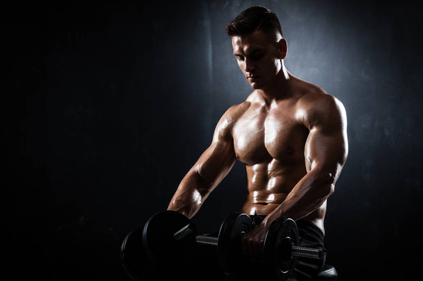 Athletic male with dumbbells - 写真・画像