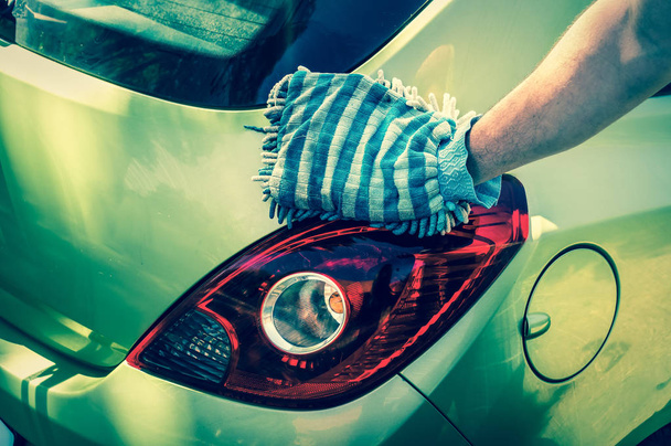 Mann wäscht sein Auto - Auto waschen und Auto reinigen Konzept - Foto, Bild