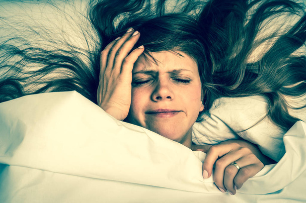 Γυναίκα στο κρεβάτι έχοντας πονοκέφαλο το πρωί - ρετρό στυλ - Φωτογραφία, εικόνα