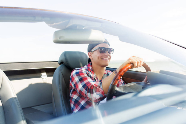 happy young man driving convertible car - 写真・画像