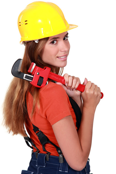 Woman brushing her hair with a pipe wrench - Foto, Imagen