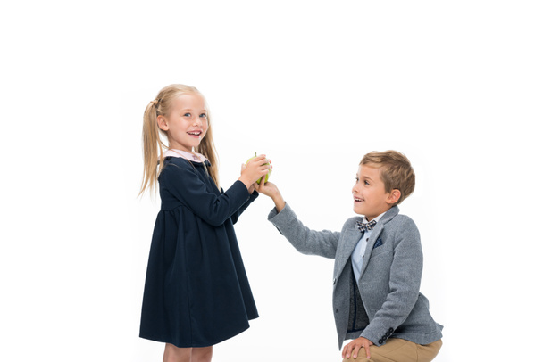 schoolboy presenting apple to girl - Foto, afbeelding