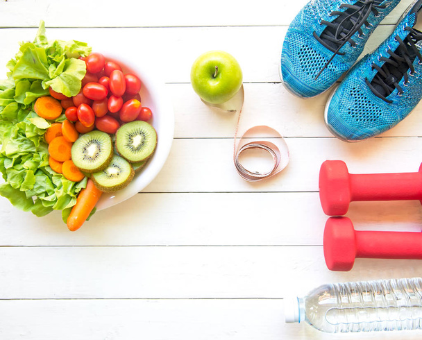 Healthy lifestyle for women diet with sport equipment, sneakers, measuring tape, vegetable fresh, green apples and bottle of water on wooden.  Healthy Concept. - Foto, afbeelding
