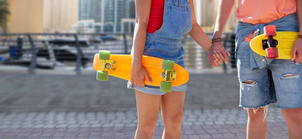 close up of young couple with skateboards in city - Fotoğraf, Görsel