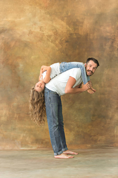 Man hugging her teenage daughter at brown - Valokuva, kuva