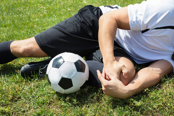 Jugador que sufre de lesión en la pierna
 - Foto, Imagen