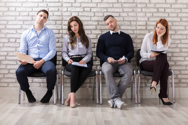 Business People Are Getting Bored While Sitting On Chair Waiting For Job Interview In Office - Photo, image