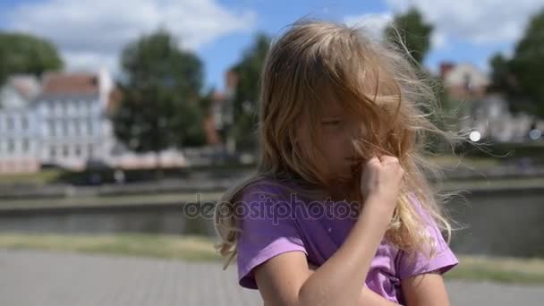 Маленькая девочка грустит на фоне летнего города
. - Кадры, видео