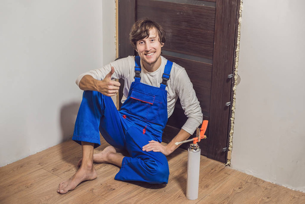 Young handyman installing door  - Foto, Bild
