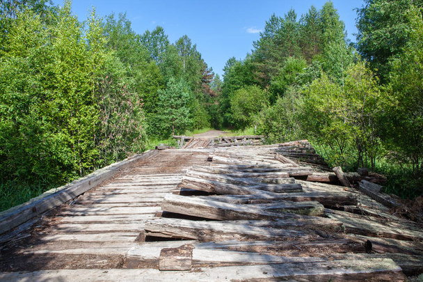 Stary zniszczony drewniany most na polnej drodze w lesie - Zdjęcie, obraz