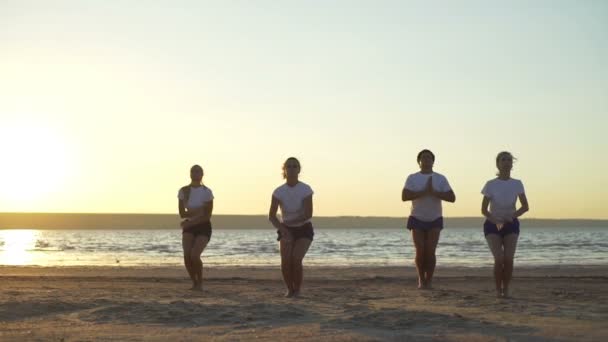 Yoga class practicing asanas at seaside sunrise namaste rapid slow motion - Footage, Video