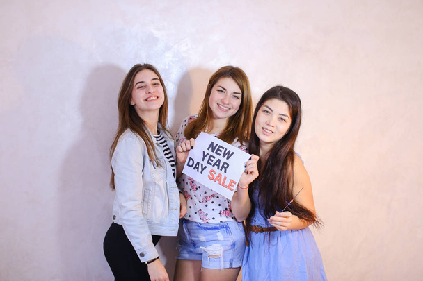 Three stylish female friends posing with sign and calling for sh - Photo, Image