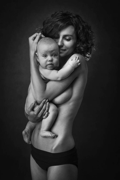 Joven madre sosteniendo un bebé en sus brazos
 - Foto, Imagen